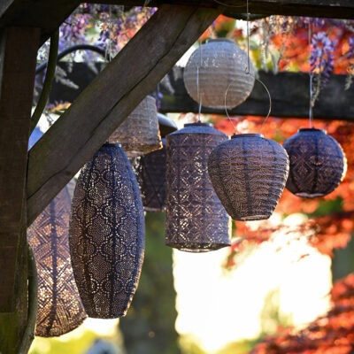 Flera solcellslanternor placerade i trädgårdsmiljö med varmt ljus