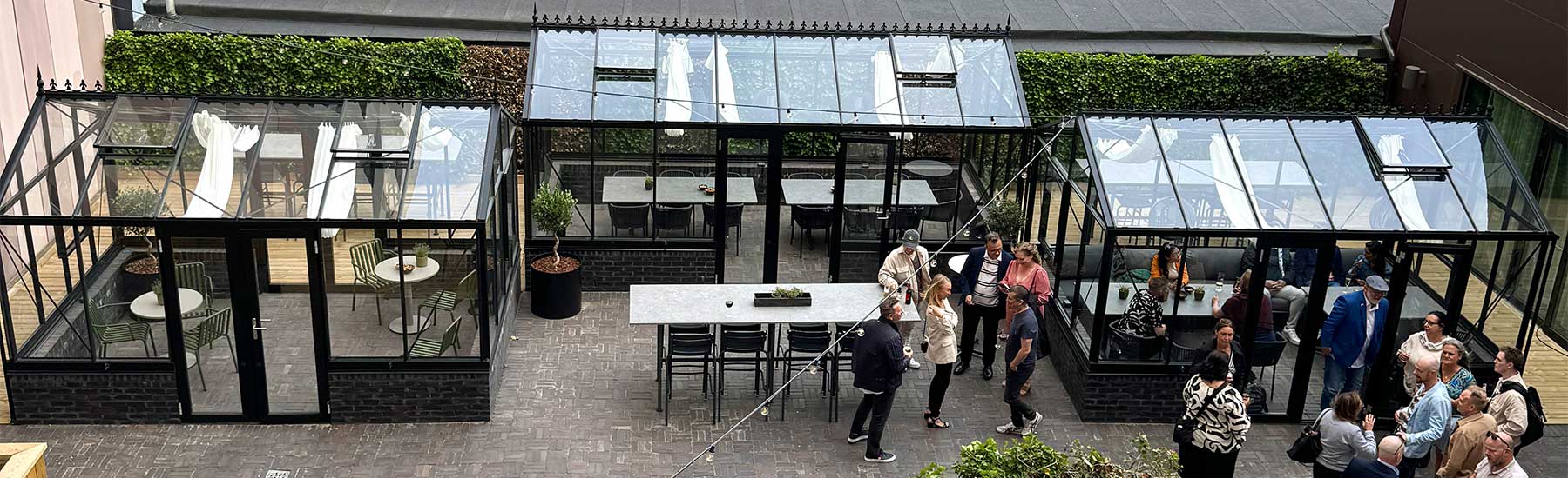 De tre orangerierna från Classicum på Malmö Arena Hotels tak lyser upp i solskenet med växter och möbler för möten och avkoppling.