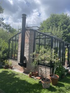 Växthus med kamin i somrig miljö