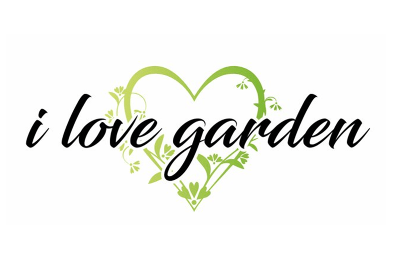 Detaljbild: Texten ”i love garden” i handskriven stil, omgiven av ett grönt hjärta av löv, passar bra i en uterum.
